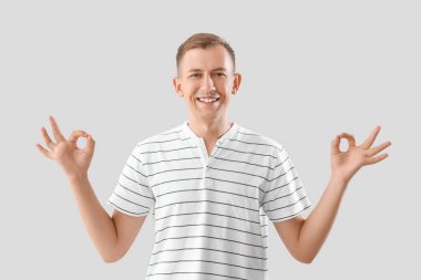 Genç adam hafif arka plan üzerinde meditasyon yapıyor.