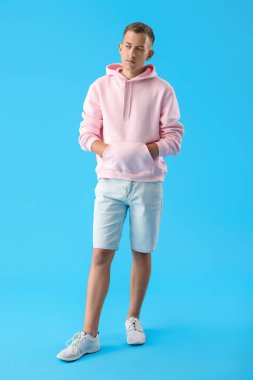 Mavi arka planda düşünceli bir genç adam.