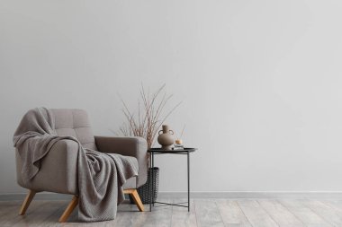 Yumuşak koltuklu, masa ve ağaç dallı modern oturma odasının içi