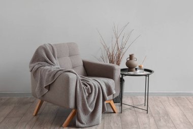 Yumuşak koltuklu, masa ve ağaç dallı modern oturma odasının içi