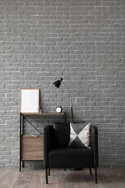 Siyah koltuğu ve raf ünitesi olan modern oturma odası.