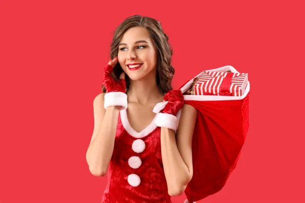 Vacker Kvinna Santa Kostym Med Påse Med Gåvor Röd Bakgrund — Stockfoto