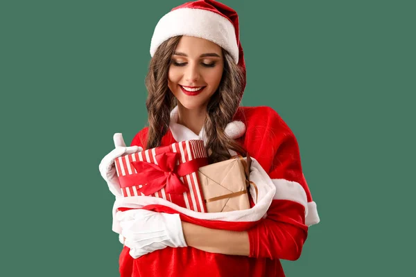 Mooie Vrouw Santa Kostuum Met Tas Van Geschenken Groene Achtergrond — Stockfoto