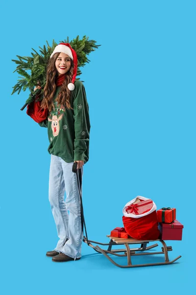 Beautiful Woman Santa Hat Christmas Tree Sledge Presents Blue Background — Stock Photo, Image