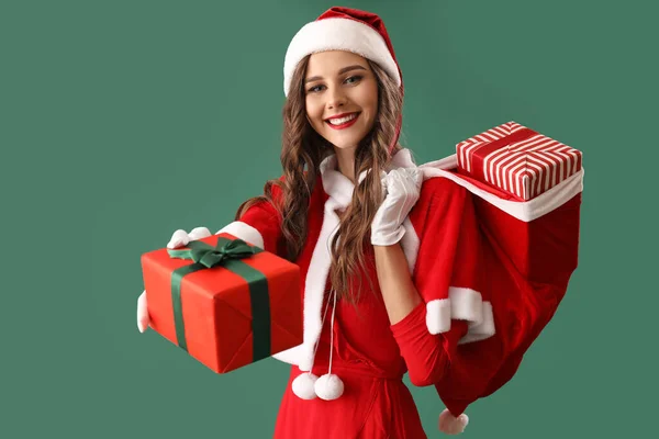 Mooie Vrouw Santa Kostuum Met Tas Van Geschenken Groene Achtergrond — Stockfoto