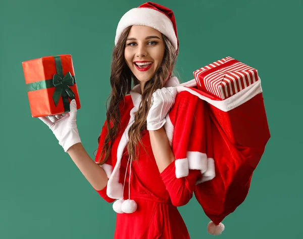 Vacker Kvinna Santa Kostym Med Påse Med Gåvor Grön Bakgrund — Stockfoto