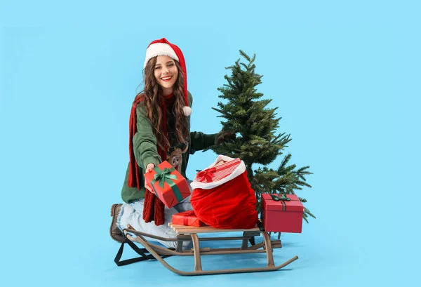 Beautiful Woman Santa Hat Christmas Tree Sledge Presents Blue Background — Stock Photo, Image