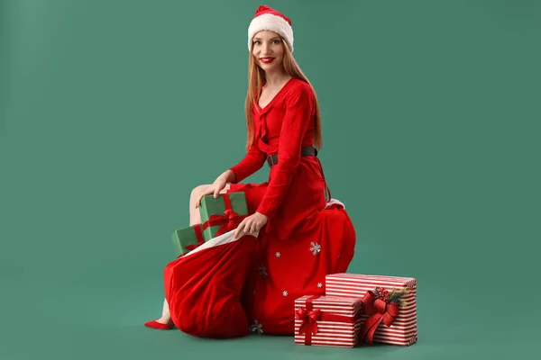 Beautiful Young Woman Santa Hat Bag Gifts Sitting Green Background — Stock Photo, Image