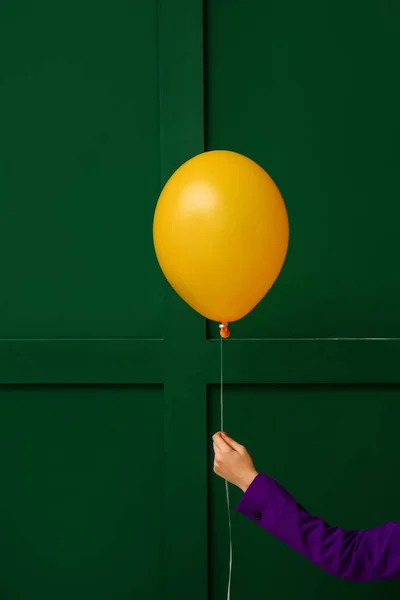 緑の壁の近くに黄色の風船の女性 — ストック写真