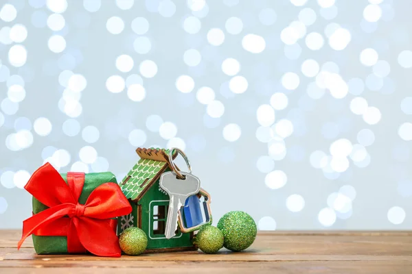 Huisfiguur Met Sleutel Cadeau Kerstdecor Tafel Tegen Wazig Licht — Stockfoto