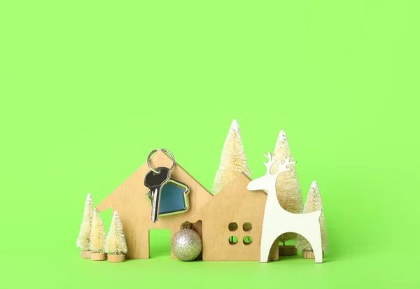 Hausfiguren Mit Schlüssel Und Weihnachtsdekor Auf Grünem Hintergrund — Stockfoto