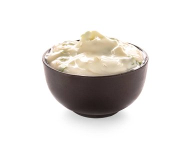 Beyaz arka planda Sezar salatası sosu olan bir kase