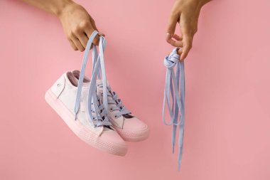Spor ayakkabılı kadın elleri ve arka planda ayakkabı bağcıkları