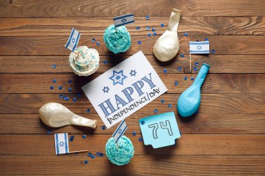 Yazılı kart Mutlu HAFTA GÜNÜ, 74 numaralı yapışkan not ve ahşap zemin üzerinde kapkekler