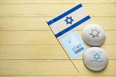 Kippah 'lar, İsrail bayrağı ve renkli ahşap arka planda DUR TERRORISM yazılı kart
