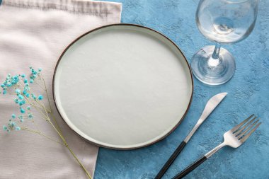 Mavi arkaplanda çiçek dekoru olan zarif masa ayarı