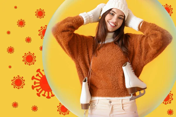 Happy woman in winter clothes and with ice skates on yellow background. Concept of strong immunity