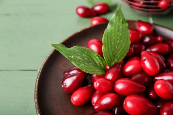 Plate Ripe Red Dogwood Berries Leaves Color Wooden Table Closeup — Stock Photo, Image