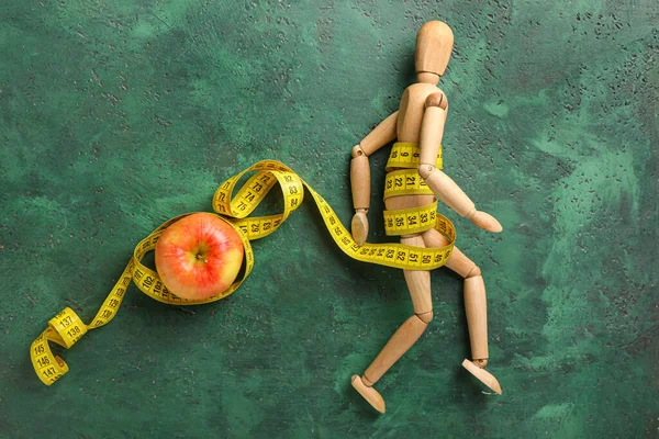 木製マネキン人形 リンゴおよび色の背景のテープを測定する 拒食症の概念 — ストック写真