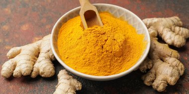 Grunge arka planında zerdeçal tozu olan bir kase, yakın plan.