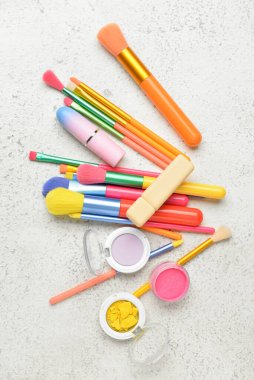 Dekoratif kozmetik ürünleri ve hafif arkaplanda fırçalar