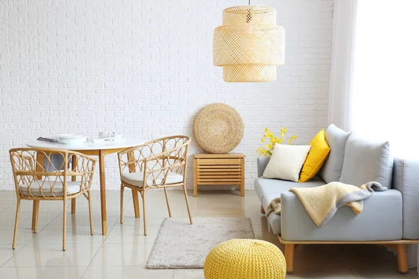 白いレンガの壁の近くに快適なソファとダイニングテーブル付きのリビングルームのスタイリッシュなインテリア — ストック写真