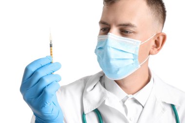 Beyaz arka planda şırıngası olan tıbbi maskeli erkek doktor, yakın plan.