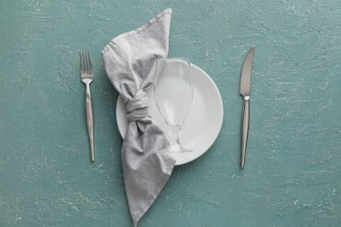 Cam kaplı basit masa ayarları, tabaktaki peçete ve renk arkaplanındaki çatal bıçak takımı