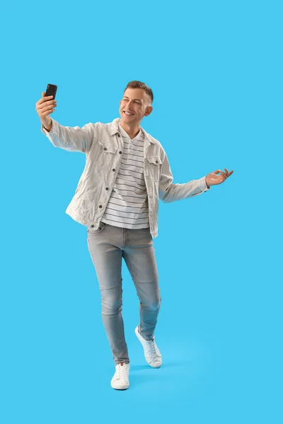 Jovem Com Telefone Celular Tirando Selfie Fundo Azul — Fotografia de Stock