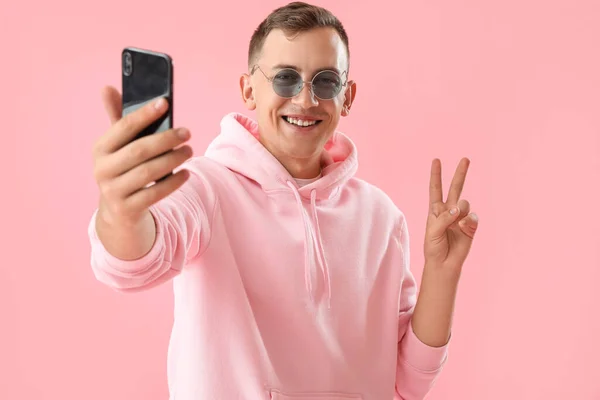 Ung Man Visar Seger Gest Medan Tar Selfie Rosa Bakgrund — Stockfoto