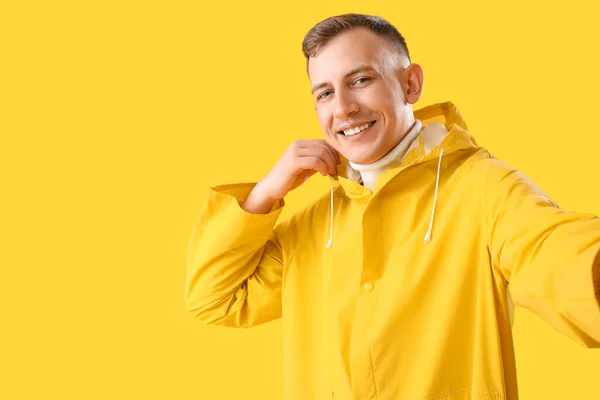 Hombre Joven Impermeable Tomando Selfie Sobre Fondo Amarillo — Foto de Stock