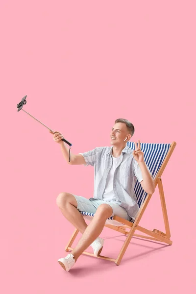 Young Man Mobile Phone Taking Selfie Deck Chair Pink Background — Stock Photo, Image