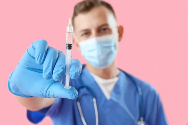 男性医師で医療マスクで注射器でピンクの背景 クローズアップ — ストック写真