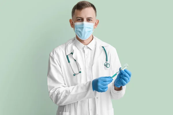 Arzt Medizinischer Maske Mit Spritze Und Ampulle Auf Grünem Hintergrund — Stockfoto