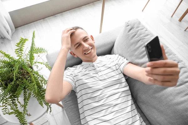 Joven Con Teléfono Móvil Tomando Selfie Sofá Casa — Foto de Stock