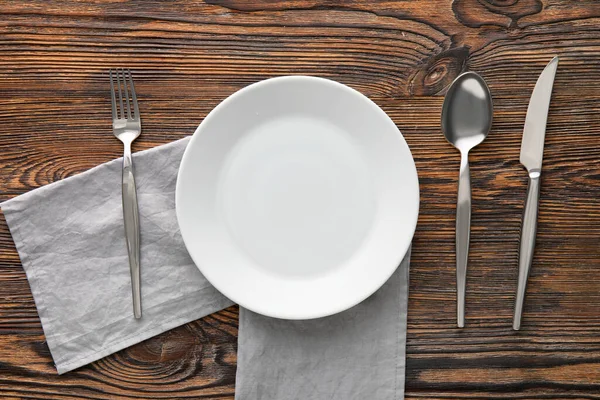 Tischdekoration Mit Teller Serviette Und Besteck Auf Holzgrund — Stockfoto