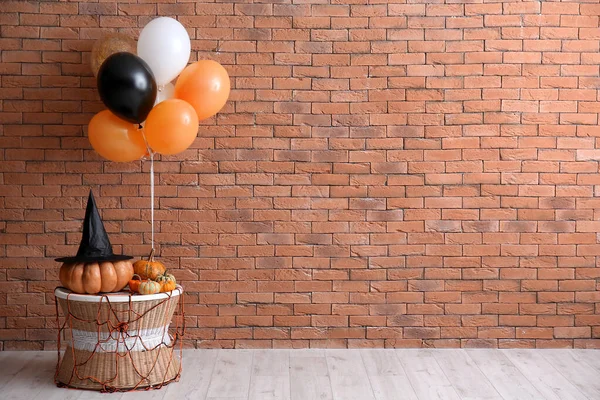 Tisch Mit Halloween Kürbissen Hexenhut Und Luftballons Nahe Ziegelmauer — Stockfoto