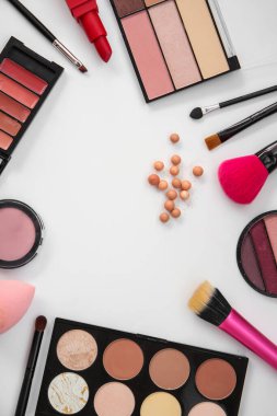 Dekoratif kozmetik ve hafif arkaplanda fırçalardan yapılmış çerçeve