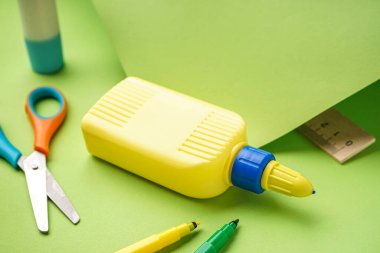 Yeşil arka planda bir şişe yapıştırıcı.