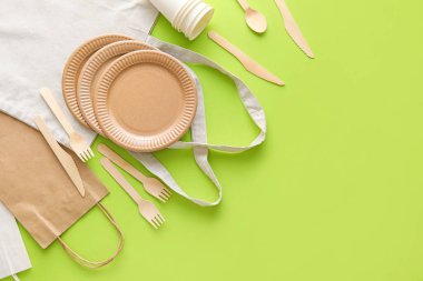 Yeşil arkaplanda farklı çantalar ve eko tablo takımı