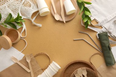 Farklı çantalardan yapılmış çerçeve, bej arka planda eko sofra takımı ve bitki dalları