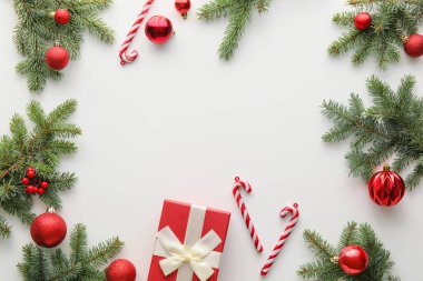 Köknar ağacı dallarından yapılmış çerçeve ve beyaz arkaplanda Noel süslemeleri