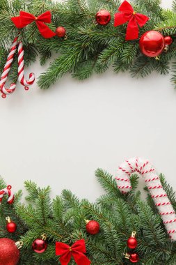Beyaz arka planda izole edilmiş köknar dalları ve dekorasyonlarıyla güzel bir Noel kompozisyonu