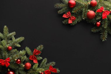 Koyu arkaplanda köknar dalları ve süslemeleri olan güzel bir Noel kompozisyonu