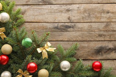 Köknar dalları ve ahşap arka planda süslemeleri olan güzel bir Noel kompozisyonu