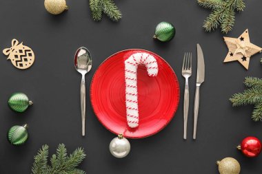 Noel baloları ve siyah arka planda köknar dallarıyla güzel bir masa.