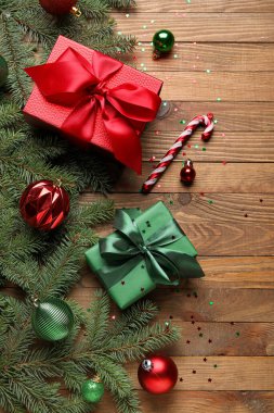 Köknar dallı kompozisyon, Noel süslemeleri ve ahşap arka planda hediyeler