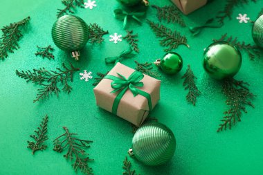 Renkli arkaplanda Noel hediyesi, dekorasyon ve thuja dallarıyla kompozisyon