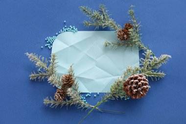 Renk arkaplan üzerinde boş kağıt ve köknar dalları ile kompozisyon