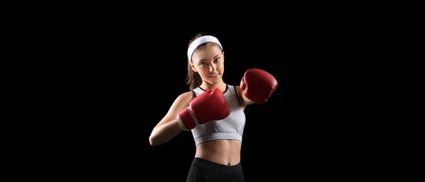 スポーティ若いです女性でボクシング手袋で黒の背景 — ストック写真